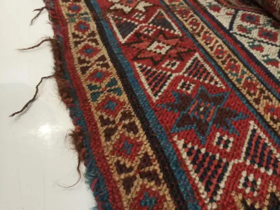 Pièce de tribu à fond rouge, bordure usée.